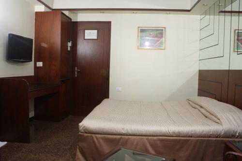 a small room with two beds and a desk at Hotel Karl Residency in Mumbai