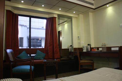 a hotel room with a desk and a window at Hotel Karl Residency in Mumbai