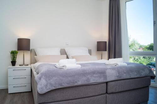 ein Schlafzimmer mit einem großen Bett und einem Fenster in der Unterkunft Südkap A-02 in Pelzerhaken