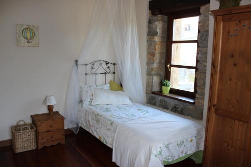 a bedroom with a white bed with a window at Amets etxalde in Santecilla