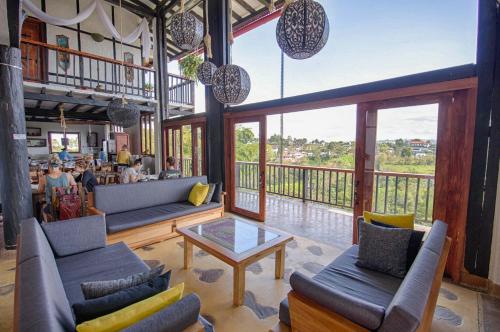 ein Wohnzimmer mit Sofas, einem Tisch und einem Balkon in der Unterkunft Coffee Tree Boutique Hostel in Salento