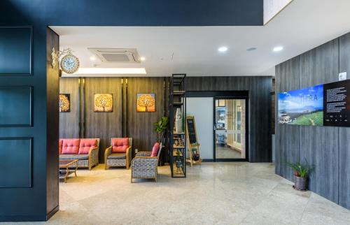 a lobby with a waiting room with red chairs at Thira Hotel in Seogwipo