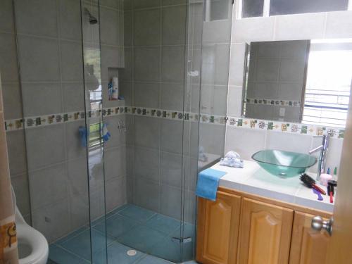 a bathroom with a glass shower and a sink at Hotel Familiar El Remanso Del Agua in Guatapé