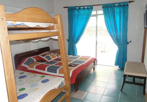 a bedroom with two bunk beds and a window at Hotel Familiar El Remanso Del Agua in Guatapé