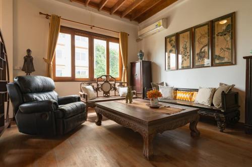 a living room with a couch and a coffee table at Artisan's Antique House - Silom in Bangkok