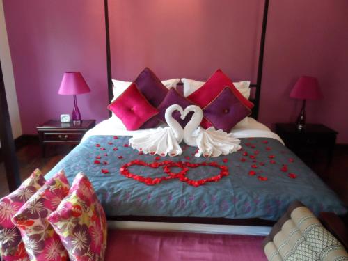 a bed with two hearts and flowers on it at Luang Prabang Nagara Villa River View in Luang Prabang