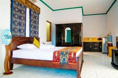 a bedroom with a large bed and a kitchen at Meriki Apartment in Seminyak