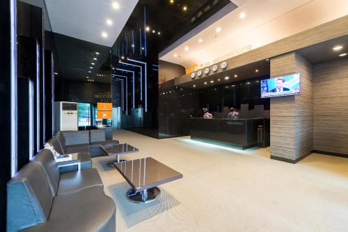 a lobby with couches and a tv in a building at Western Coop Hotel & Residence Dongdaemun in Seoul