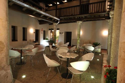 a restaurant with tables and chairs in a room at Evenia Alcalá Boutique Hotel in Alcalá de Henares