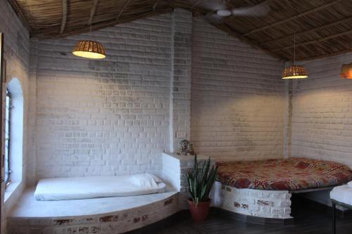 Habitación con cama en una pared de ladrillo en Shannu's Ranch Inn, en Pushkar