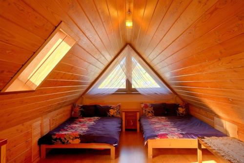 um quarto com 2 camas num chalé de madeira em Apartament Dana em Poronin