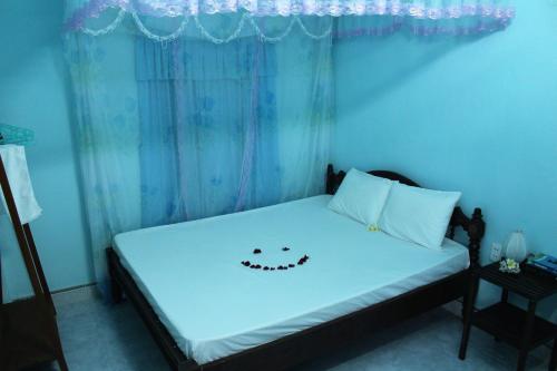 a bedroom with a bed with a face drawn on it at Cham Island Smiles Homestay in Tân Hiệp