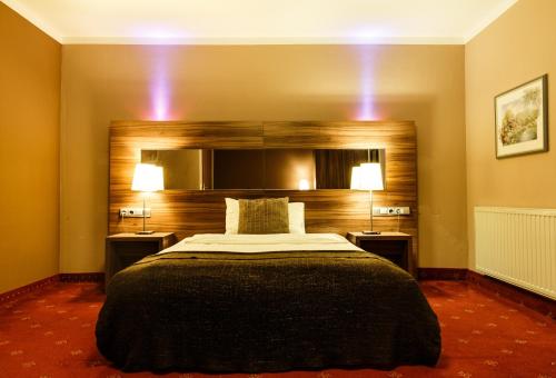 ein Schlafzimmer mit einem großen Bett mit zwei Leuchten in der Unterkunft Hotel Salzburg in Salzburg