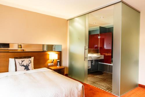 a bedroom with a bed and a sliding glass door at Hotel Salzburg in Salzburg