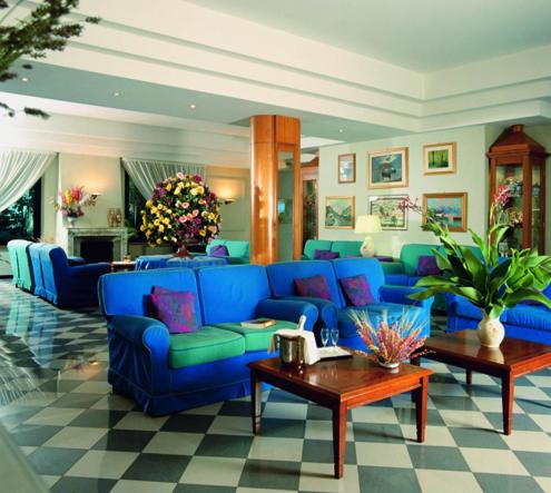 a living room with a blue couch and a table at Platani Hotel in Bolsena