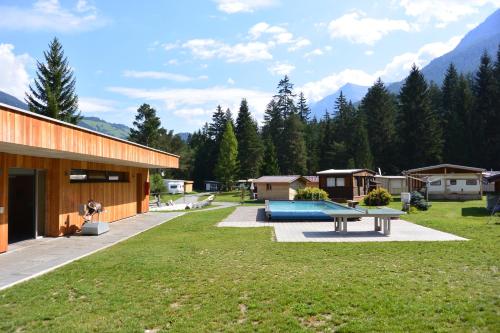 a large yard with a picnic table next to a building at Camping Sur En in Sent