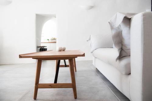 a wooden table next to a white couch at Native Eco Villas in Imerovigli