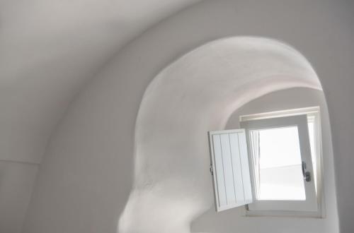 a white room with a door and a window at Native Eco Villas in Imerovigli