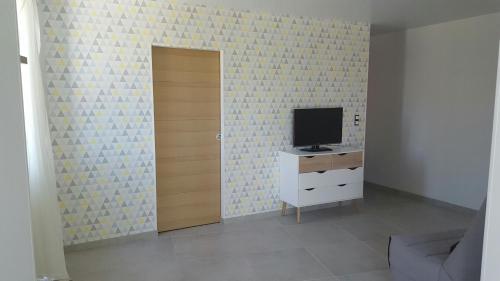 um quarto com uma televisão numa cómoda e uma porta em T2 de 45 m2 sur Porticcio avec Jardin em Porticcio