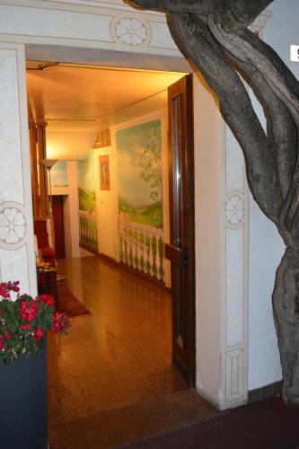 a hallway with an open door with a tree at Alla Posta Guest House in Garna dʼAlpago