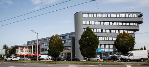 a building with cars parked in a parking lot at Hotel Salzburg in Salzburg