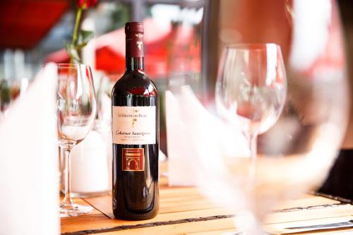 a bottle of wine sitting on a table with glasses at Hotel Salzburg in Salzburg