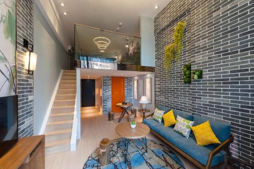 a living room with a blue couch and a brick wall at Yumi Apartment Lida Plaza Branch in Guangzhou