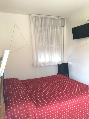 a bedroom with a red bed with a window at Hotel San Marco BB in Boario Terme
