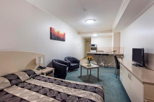 a hotel room with a bed and a desk at Comfort Inn & Suites Goodearth Perth in Perth