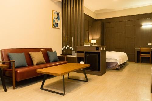 a hotel room with a couch and a bed at V-Hotel in Taitung City