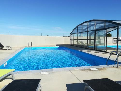 une piscine devant un immeuble dans l'établissement Plénisud, à Pomérols