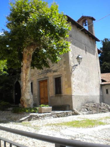 a building with a tree in front of it at Il Nido in Rezzonico
