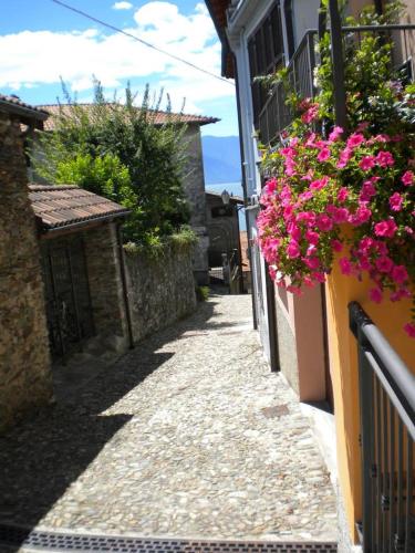 an alley with flowers on the side of a building at Il Nido in Rezzonico