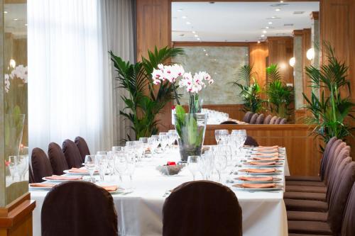 a long table with glasses and flowers on it at VP Jardín de Tres Cantos in Tres Cantos