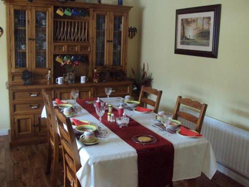 a dining room table with a white table cloth and chairs at Ryebrook House in Killarney