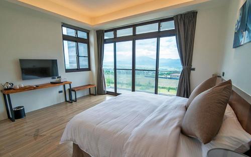a bedroom with a large bed and a large window at Yulaikung B&B in Yongan