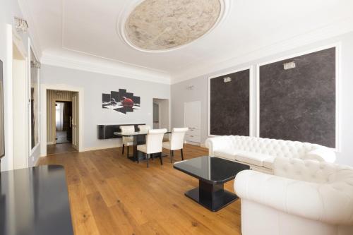 a living room with a white couch and a table at Wellness Hotel Republika 24 Apartments in Plzeň