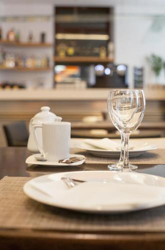 a wooden table with a plate and a wine glass at Soho Boutique Casa Don Fernando in Cáceres