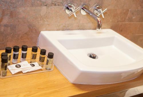 a bathroom sink and a group of cosmetics on a counter at Soho Boutique Casa Don Fernando in Cáceres