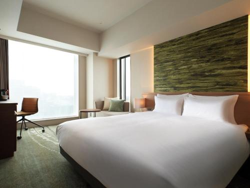 a hotel room with a large bed and a large window at Hotel Metropolitan Sendai East in Sendai