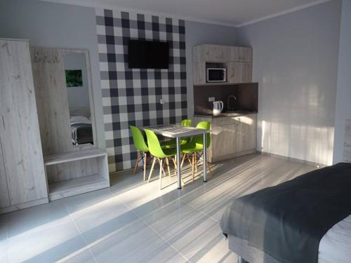 uma cozinha com mesa e cadeiras num quarto em Apartamenty Wilczyca em Wilczyn