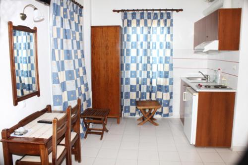 a kitchen with a table and chairs and a kitchen with a sink at Villa Kriezi in Spetses