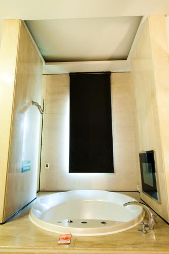 a large bath tub in a room with a large window at Her Home Spa Motel Chiayi in Chiayi City