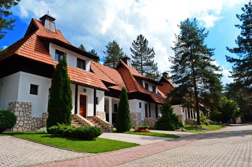 a house with a red roof on a street at KRALjEVI KONACI ZLATIBOR in Zlatibor