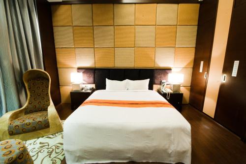 a hotel room with a bed and a chair at Her Home Spa Motel Chiayi in Chiayi City