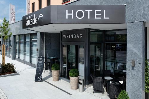 a hotel with tables and chairs outside of a building at Hotel Arcade in Sins