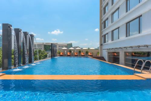 a large swimming pool on the side of a building at Feathers- A Radha Hotel, Chennai in Chennai
