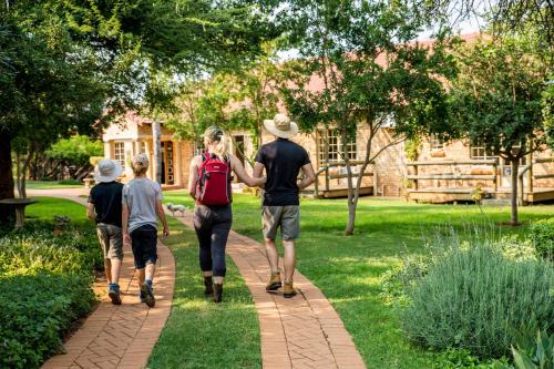 three people walking down a path in a park at Boubou Bed and Breakfast in Rustenburg