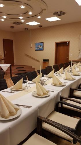 a conference room with white tables and chairs with napkins at Hotel Restaurant Paelzer-Buwe in Haßloch
