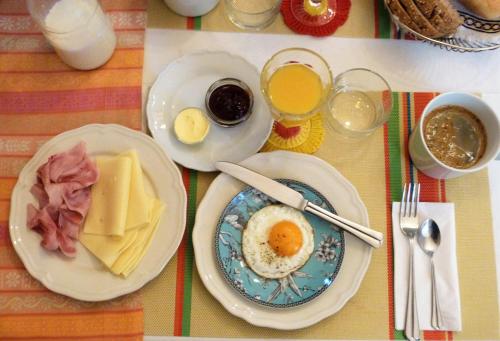 a table with plates of breakfast foods and drinks at Family Hotel Okoř in Okoř
